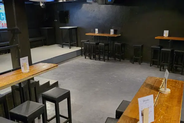 Keller-Club – Stehtische aus Holz rund um die Tanzfläche