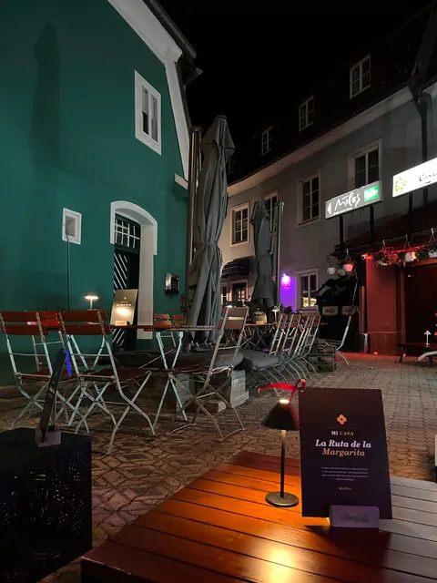 Terrasse mit Margarita-Karte vor dem grünen Haus